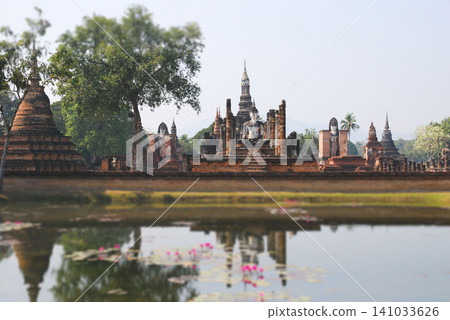 Ancient ruins of Wat Mahathat mirrored in water at Sukhothai Historical Park Thailand Ancient ruins of Wat Mahathat mirrored in water at Sukhothai Historical Park Thailand 141033626