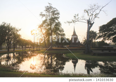 Scenic reflection of a Buddhist stupa in a pond at sunset in Sukhothai Scenic reflection of a Buddhist stupa in a pond at sunset in Sukhothai 141033630