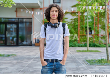 Young happy student with backpack standing outside school Young happy student with backpack standing outside school 141033651