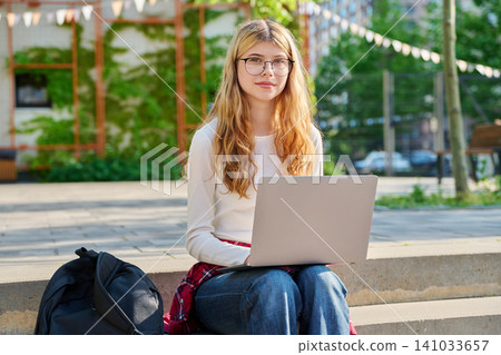 Happy teenage student with laptop on school campus 141033657