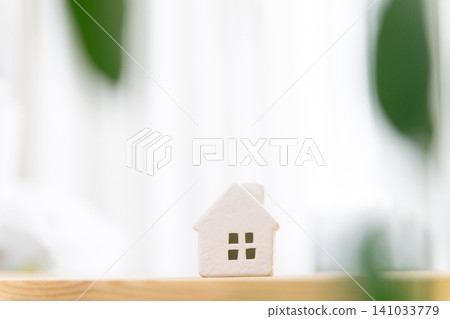 A miniature house (my home/residential) placed on a table in a brightly lit room, with copy space. A miniature house (my home/residential) placed on a table in a brightly lit room, with copy space. 141033779