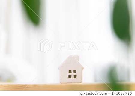 A miniature house (my home/residential) placed on a table in a brightly lit room, with copy space. A miniature house (my home/residential) placed on a table in a brightly lit room, with copy space. 141033780