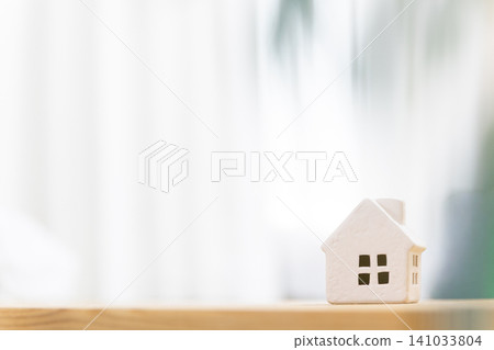 A miniature house (my home/residential) placed on a table in a brightly lit room, with copy space. A miniature house (my home/residential) placed on a table in a brightly lit room, with copy space. 141033804
