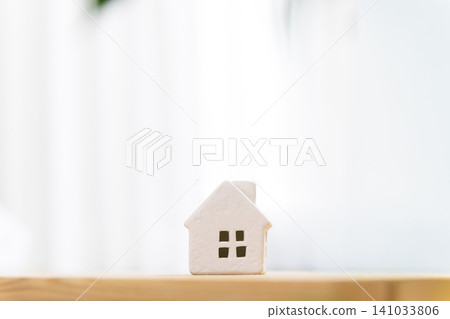 A miniature house (my home/residential) placed on a table in a brightly lit room, with copy space. A miniature house (my home/residential) placed on a table in a brightly lit room, with copy space. 141033806