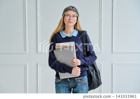 Smiling teenage student girl with backpack and laptop 141033961