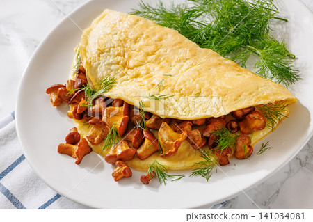 Egg omelet with fried wild chanterelles and dill Egg omelet with fried wild chanterelles and dill 141034081