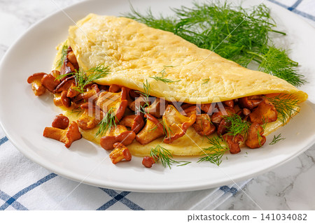 Egg omelet with fried wild chanterelles and dill Egg omelet with fried wild chanterelles and dill 141034082