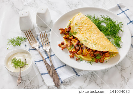 Egg omelet with fried wild chanterelles and dill Egg omelet with fried wild chanterelles and dill 141034083