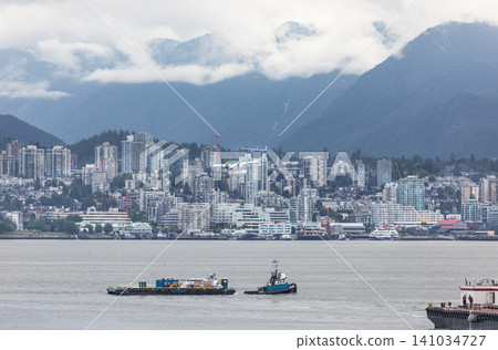 Cityscape view of North Vancouver from downtown Vancouver British Columbia Canada with bay of water and boats. Modern housing development. Travel photo, editorial. July 10,2022 Cityscape view of North Vancouver from downtown Vancouver British Columbia Canada with bay of water and boats. Modern housing development. Travel photo, editorial. July 10,2022 141034727