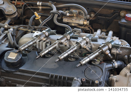 Closeup of modern diesel engine cylinder head with injectors Closeup of modern diesel engine cylinder head with injectors 141034735