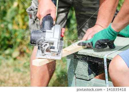 Close up of circular saw cutting wooden board during carpentry work Close up of circular saw cutting wooden board during carpentry work 141035418