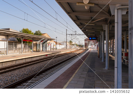 Spanish Commuter Train Station Platform with Railway Tracks at Golden Hour Spanish Commuter Train Station Platform with Railway Tracks at Golden Hour 141035632