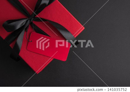 Red gift box with black ribbon and blank tag 141035752