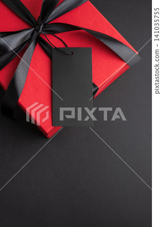 Red gift box with black ribbon and blank tag Red gift box with black ribbon and blank tag 141035755