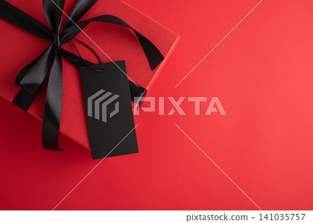 Red gift box with black ribbon and blank tag Red gift box with black ribbon and blank tag 141035757