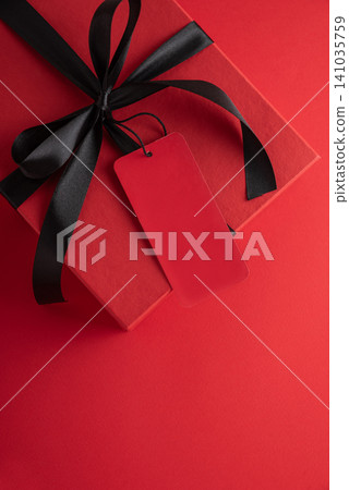 Red gift box with black ribbon and blank tag Red gift box with black ribbon and blank tag 141035759