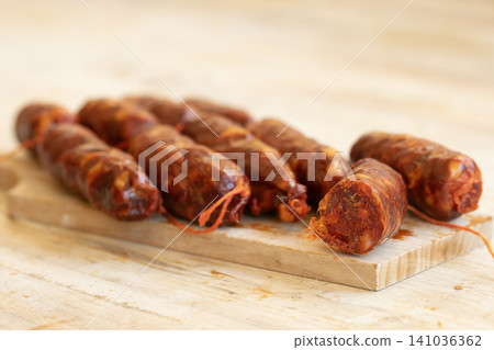 Sliced Spanish Chorizo Sausages on Wooden Cutting Board Sliced Spanish Chorizo Sausages on Wooden Cutting Board 141036362