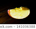 TITLE: Apple slice on dark wooden table 141036388