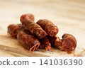 Sliced Spanish Chorizo Sausages on Wooden Cutting Board 141036390