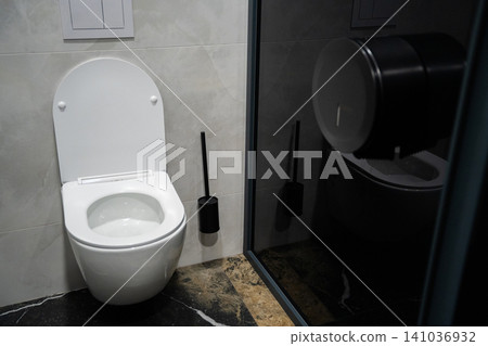 Modern public restroom with high hygiene standards featuring a sleek design. Cleanliness sanitation and commercial bathroom facility 141036932
