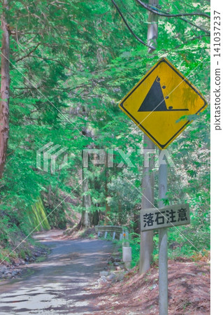 森林中的警告標誌:小心落石,注意行車安全,注意交通安全,注意危險,注意垂直拍攝。 森林中的警告標誌:小心落石,注意行車安全,注意交通安全,注意危險,注意垂直拍攝。 141037237