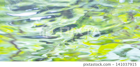 圖片素材描繪了森林的蔥鬱綠意、清澈的溪流以及夏日色彩倒映在水面上的景象。 141037915