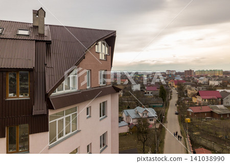 High apartment building with many windows and metal sheets roof. High apartment building with many windows and metal sheets roof. 141038990
