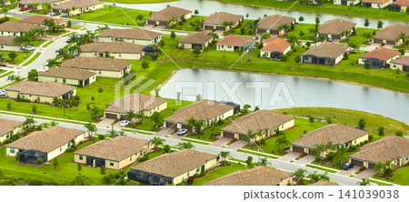 Aerial view of tightly located family houses with retention ponds to prevent flooding in Florida closed suburban area. Real estate development in american suburbs Aerial view of tightly located family houses with retention ponds to prevent flooding in Florida closed suburban area. Real estate development in american suburbs 141039038