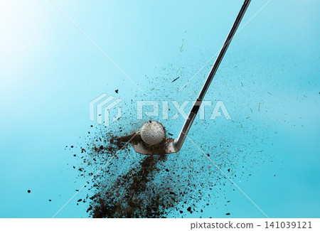 Golf ball explode from Tee off. Golfer hit ball with metal iron club to grass soil explosion on green. Golf club hit ball on green tee off with grass flying scatter. Blue Sky background isolated 141039121
