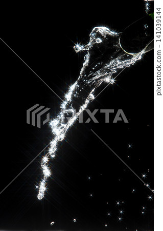 Water splash reflect bright light, producing starburst effect and shining flare, almost like falling star. Splash water under light show sparkle light flare, created bright abstract reflection Water splash reflect bright light, producing starburst effect and shining flare, almost like falling star. Splash water under light show sparkle light flare, created bright abstract reflection 141039144