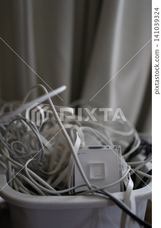 Tangled power cables. White charging cords. A messy, tangled mess. Tangled power cables. White charging cords. A messy, tangled mess. 141039324