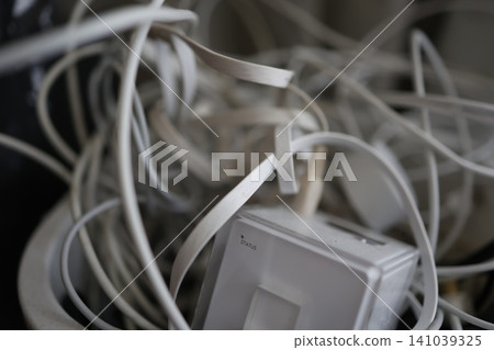 Tangled power cables. White charging cords. A messy, tangled mess. Tangled power cables. White charging cords. A messy, tangled mess. 141039325