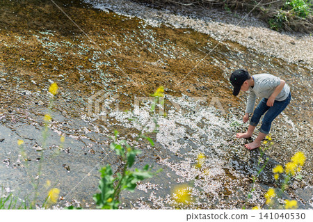 A boy playing in the river, basking in the pleasant spring sunshine. A boy playing in the river, basking in the pleasant spring sunshine. 141040530