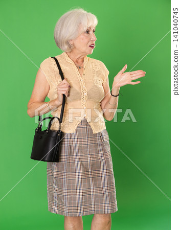 Elderly woman looking around in front of green screen Elderly woman looking around in front of green screen 141040745