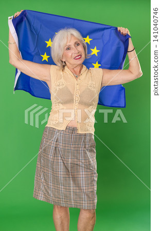 Elderly woman holding EU flag in front of green screen Elderly woman holding EU flag in front of green screen 141040746