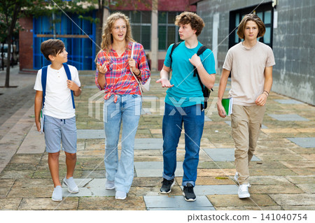 Group of positive cheerful teenagers hanging out on streets of city on day Group of positive cheerful teenagers hanging out on streets of city on day 141040754