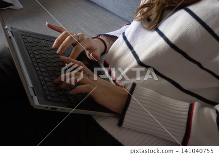 Woman working remotely from home, typing on a laptop, feeling stressed and concentrated while facing a deadline and experiencing work frustration 141040755