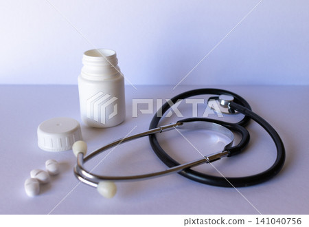 Capsules with medication packaging next to a stethoscope. Light background Capsules with medication packaging next to a stethoscope. Light background 141040756