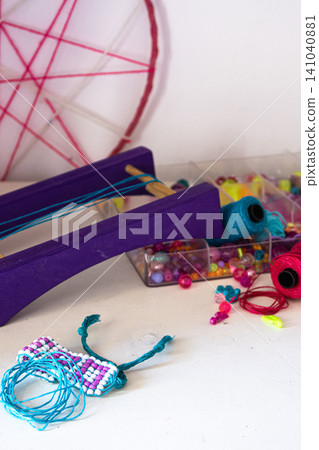 Loom beading craft on a white desktop, creating colorful handmade jewelry like bracelets for creative expression, skill development, and unique designs Loom beading craft on a white desktop, creating colorful handmade jewelry like bracelets for creative expression, skill development, and unique designs 141040881