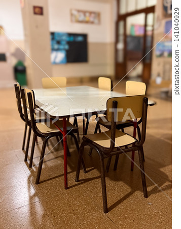 Empty classroom during school break or vacation, featuring a table with chairs in the foreground and a blurred world map providing a global education context in the background Empty classroom during school break or vacation, featuring a table with chairs in the foreground and a blurred world map providing a global education context in the background 141040929