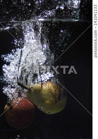 Two fresh pears splashing into clear water creating bubbles Two fresh pears splashing into clear water creating bubbles 141041133