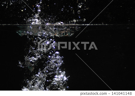 Water bubbling up creating fresh splash on black 141041148