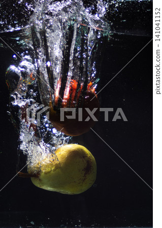Fruits falling into water creating splash and bubbles. Fresh and healthy summer concept Fruits falling into water creating splash and bubbles. Fresh and healthy summer concept 141041152