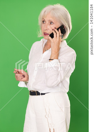 Happy woman in white clothes is talking to someone on mobile phone. Chroma key compositing 141041184