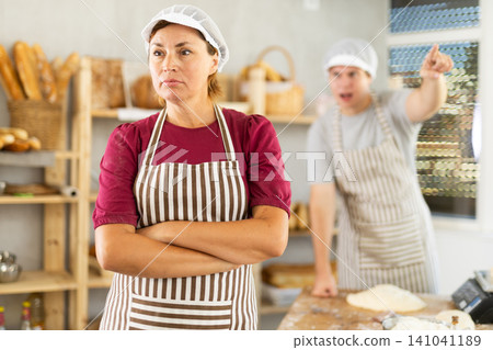 In bakery, confused female employee during quarrel with guy boss In bakery, confused female employee during quarrel with guy boss 141041189