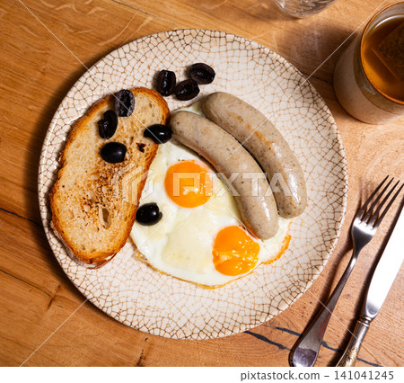 Fried eggs served with sausages for breakfast Fried eggs served with sausages for breakfast 141041245