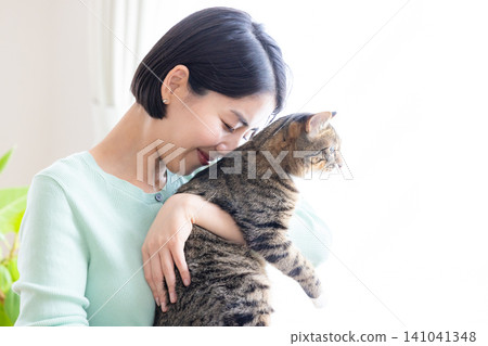 A woman holding her pet cat. A woman holding her pet cat. 141041348