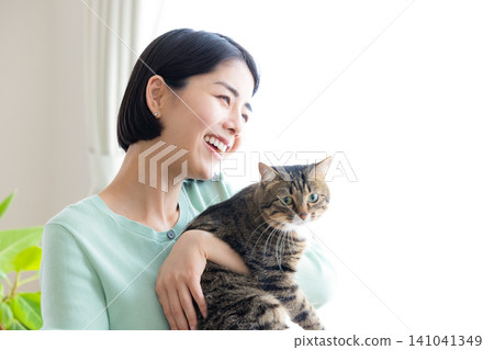 A woman holding her pet cat. A woman holding her pet cat. 141041349