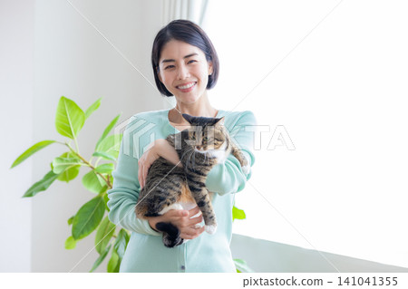 A woman holding her pet cat. A woman holding her pet cat. 141041355