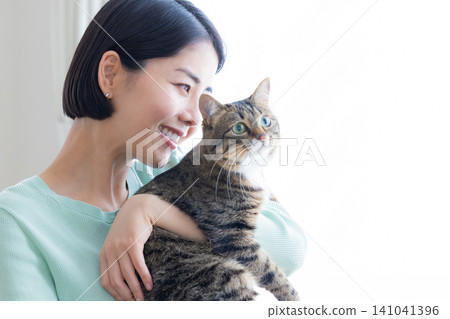 A woman holding her pet cat. A woman holding her pet cat. 141041396